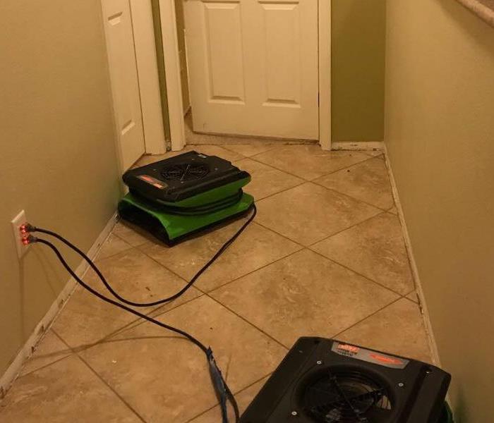 Hallway with green air movers on the tile.