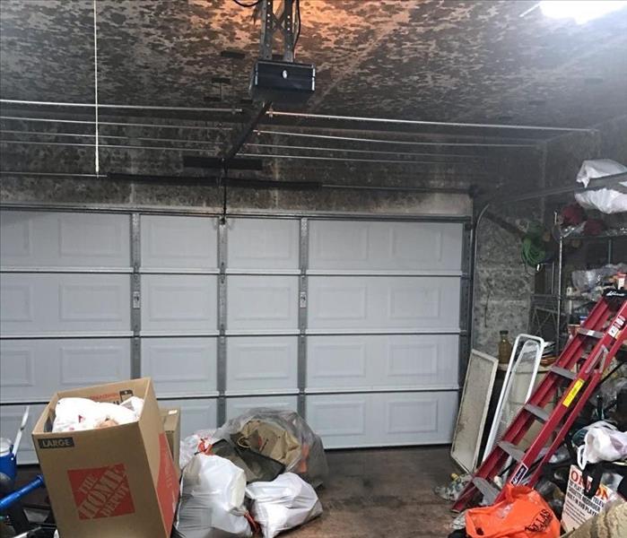 Inside of a garage with soot spots on the ceiling. 
