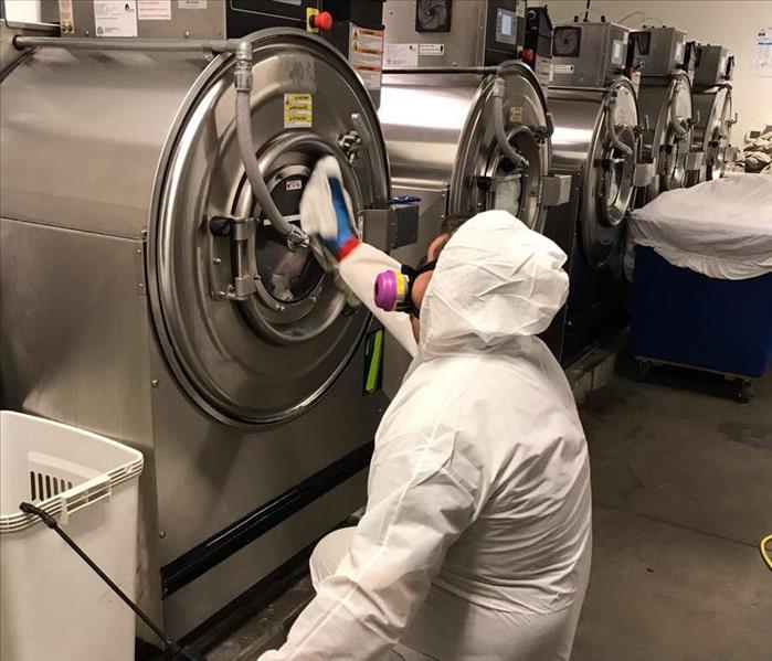Employee cleaning a washer